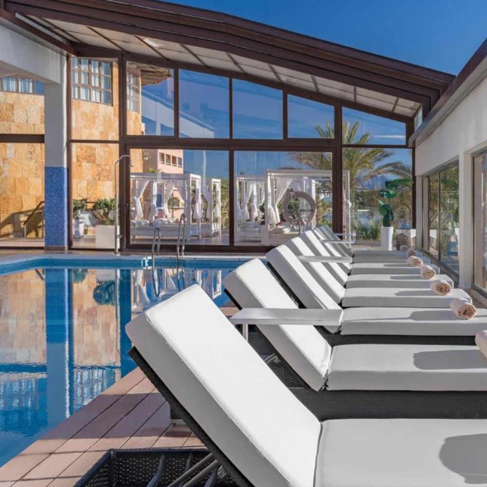 Indoor swimming pool with loungers.