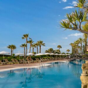 Piscina de un complejo turístico tropical con palmeras