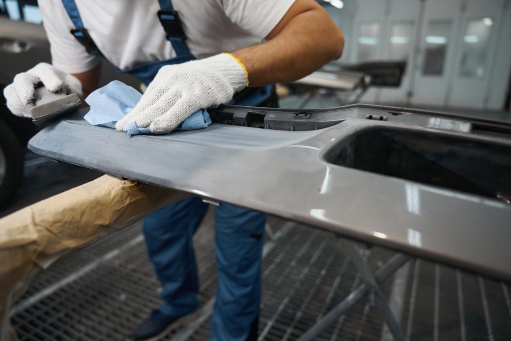 Technician working on aluminum car body panel repair at European Autoworks.