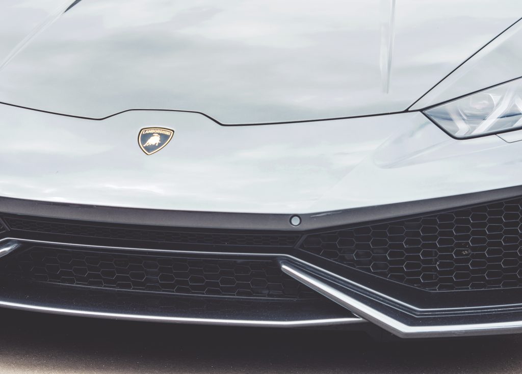 Close-up of Lamborghini front with carbon fiber damage on the bumper.