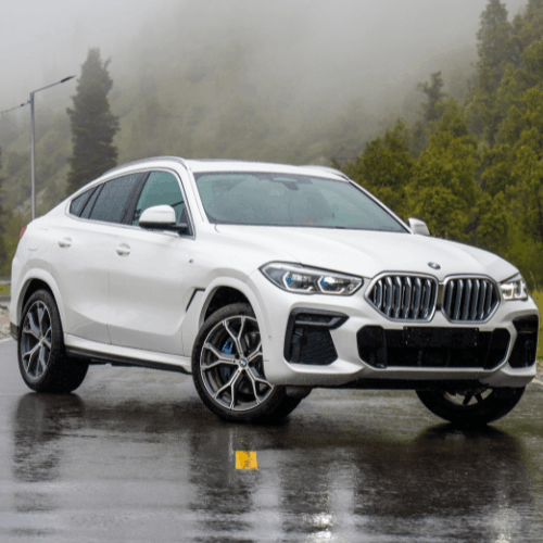 BMW X4 SUV on a rainy road, ready for vehicle maintenance.