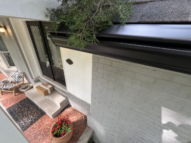 Image shows a clean, professional gutter system installed on a house's exterior.