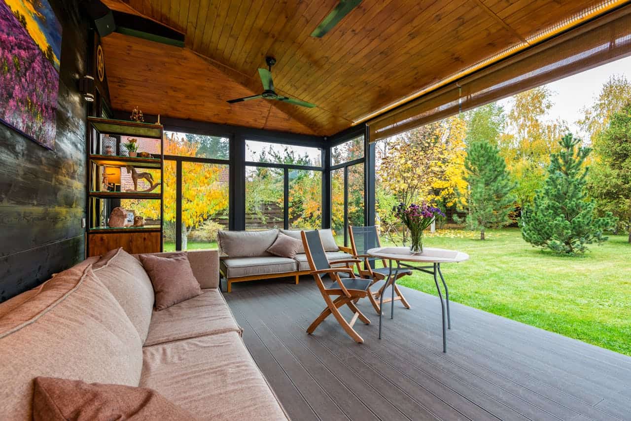 about-us Elegant modern porch with comfortable seating and vibrant garden view.