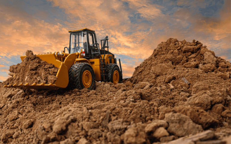 A wheel loader and a backhoe loader working side by side at a construction site, demonstrating their unique functionalities in handling and moving materials.