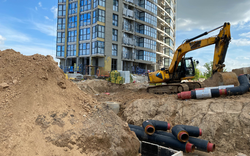 Excavation and Trenching: A large, open trench at a construction site with heavy machinery nearby
