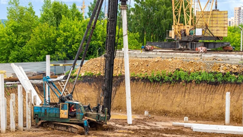 The driver is operating the pile driver to drive the concrete pile