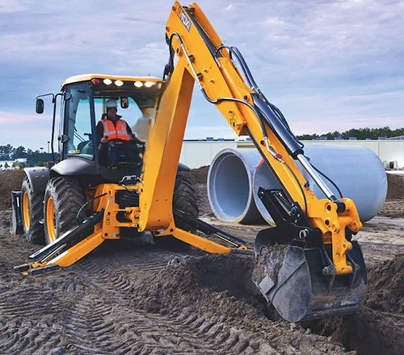 Everstar‘s’ backhoe with an operator in a safety vest, next to large concrete pipes at a construction site.