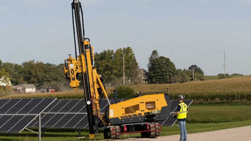 The operator uses a remote control to operate the solar pile driver