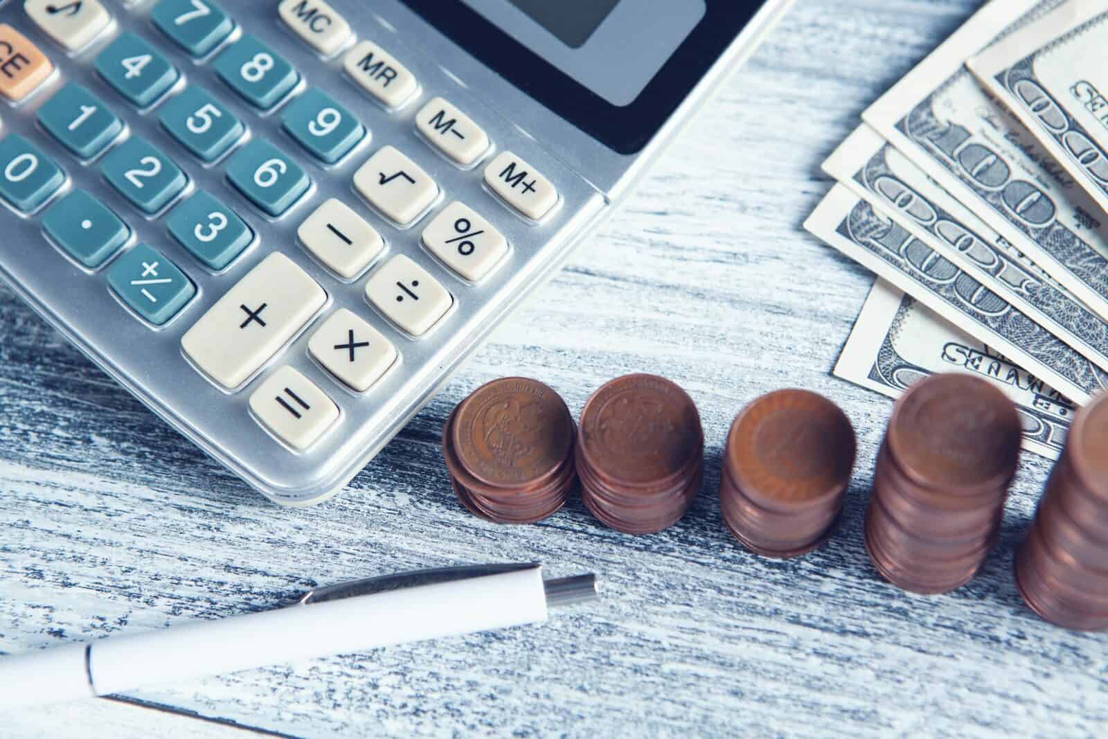 Calculator, coins, and dollar bills for small business tax planning.