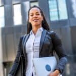 Tax professional woman standing confidently outside modern office building.