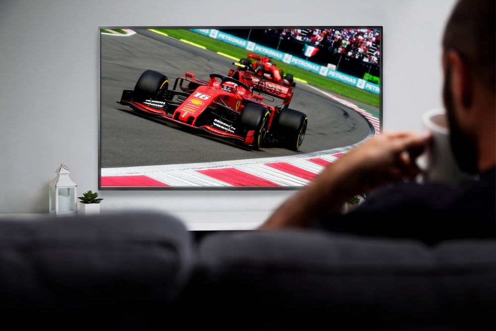 Man watching formula racing on smart TV. Live racing transmission. ROSARIO, ARGENTINA - MARCH 2, 2023. — Photo by AlexRuhl
