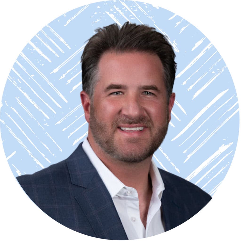 A portrait of Joey, wearing a suit and smiling against a light blue background.