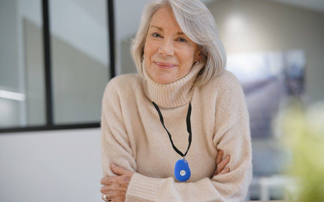 Elderly woman wearing a personal medical alarm for safety and emergency assistance.