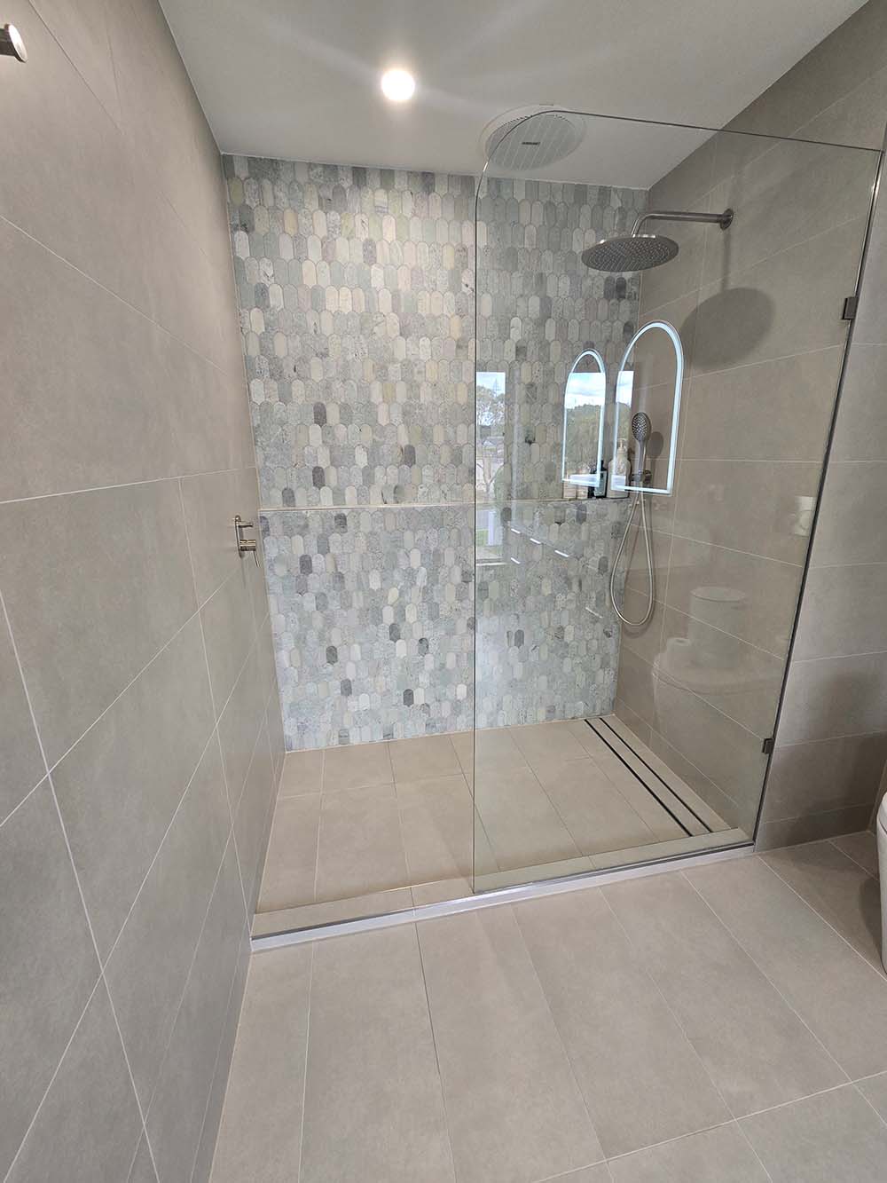 Bathroom shower with glass enclosure and contemporary fixtures.