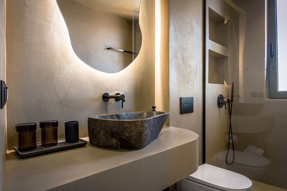 Contemporary bathroom with stone sink, modern fixtures, and sleek decor.