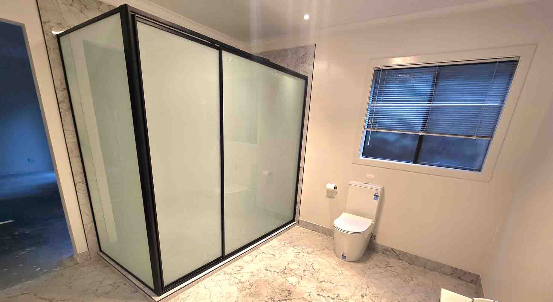 Stylish black-framed shower screen in a modern bathroom setting.