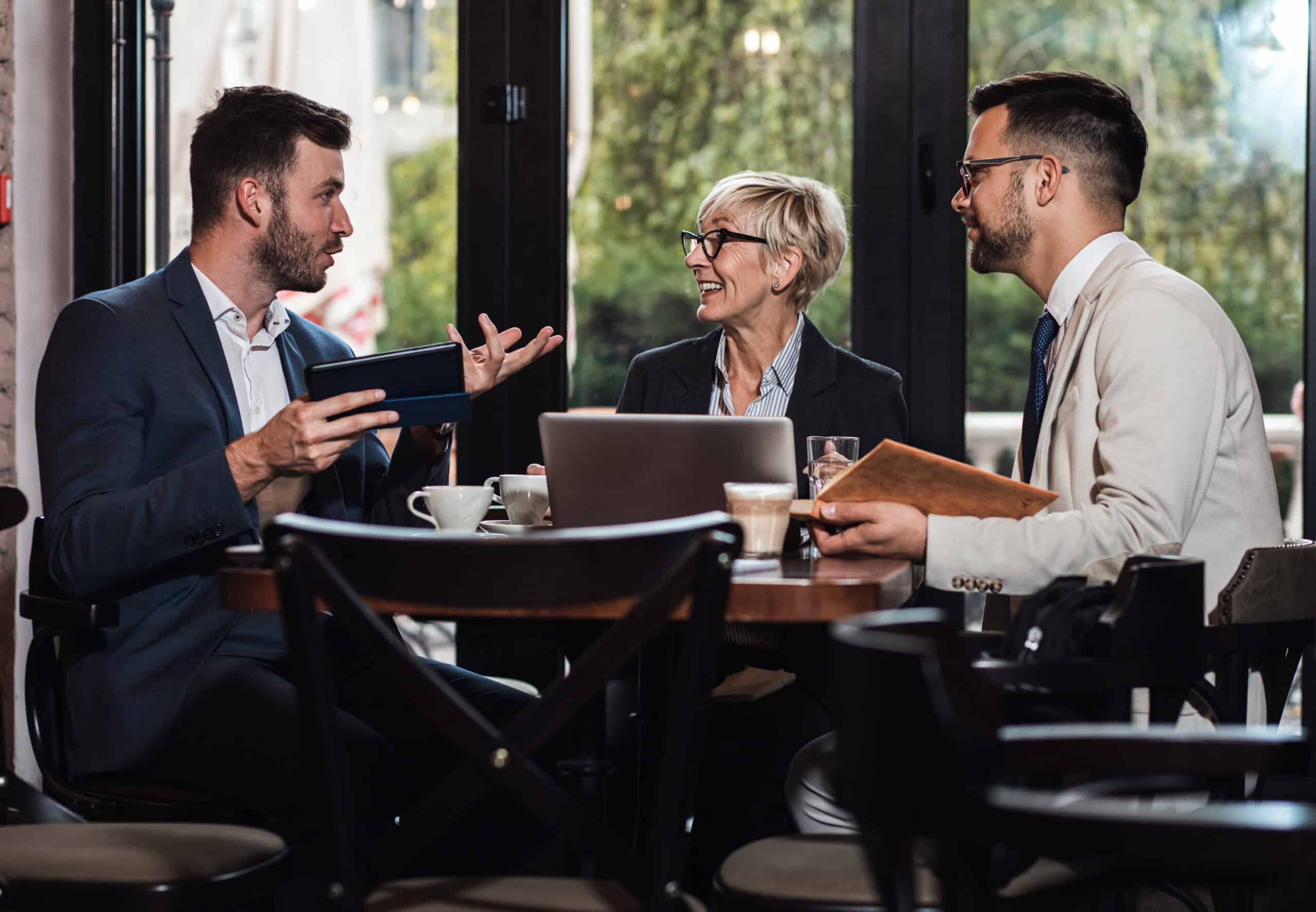 Two colleagues in conversation, one introducing a new contact, representing customer advocacy and referral in action