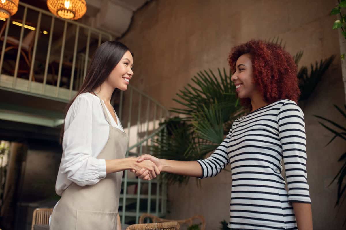 Business owner and a referred customer shaking hands, representing a referral generating business