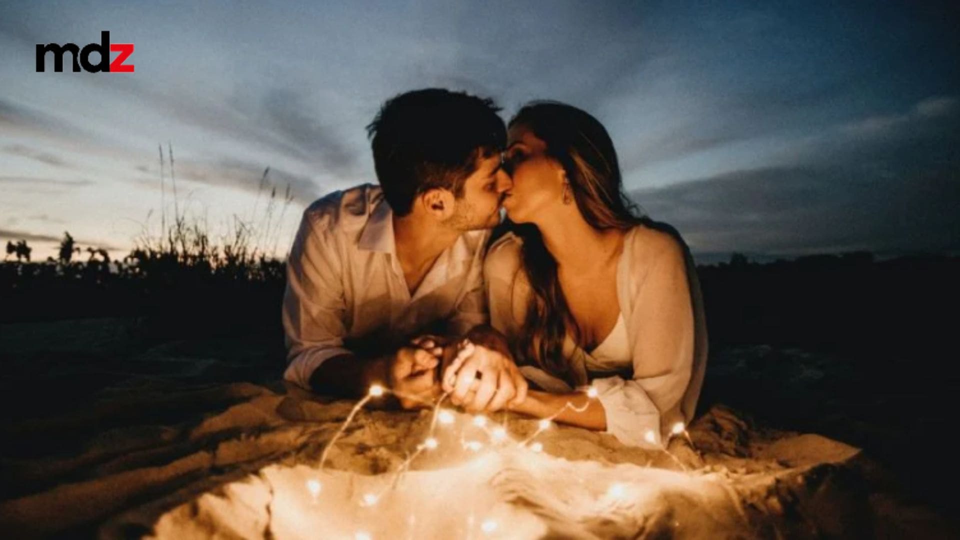 Amor romántico en la naturaleza con velas y puesta de sol al atardecer.