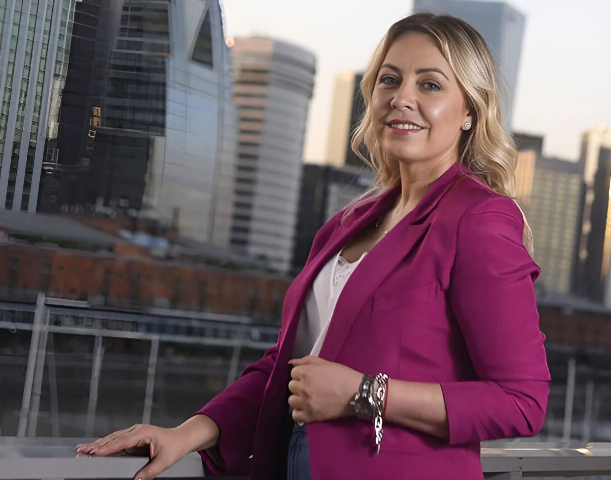 Mujer profesional en ciudad moderna con edificios altos de fondo.