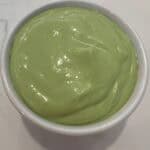 Picture of a white bowl filled with a vibrant lemon basil Greek yogurt dressing.
