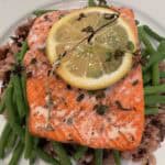 Picture of Grilled Wild Sockeye Salmon with Lemon & Thyme sitting on a bead of wild rice and green beans.