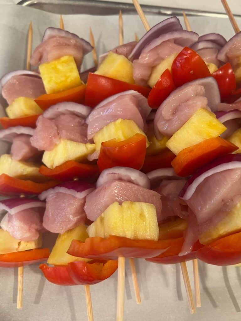 Picture of assembled raw Pineapple Chicken Kabobs. 