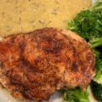 picture of sweet and savory chicken breast plated with creamy polenta and broccoli.