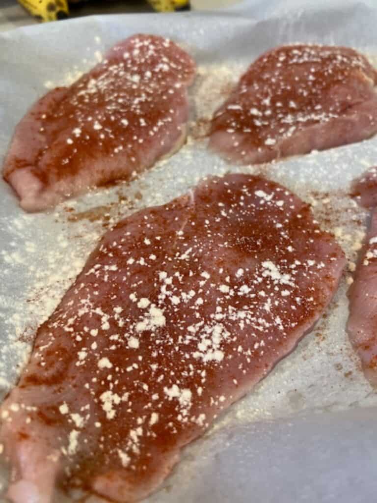 Picture of raw sweet and savory chicken breasts on a sheet pan.