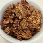 Picture of pumpkin spiced granola in a white bowl.