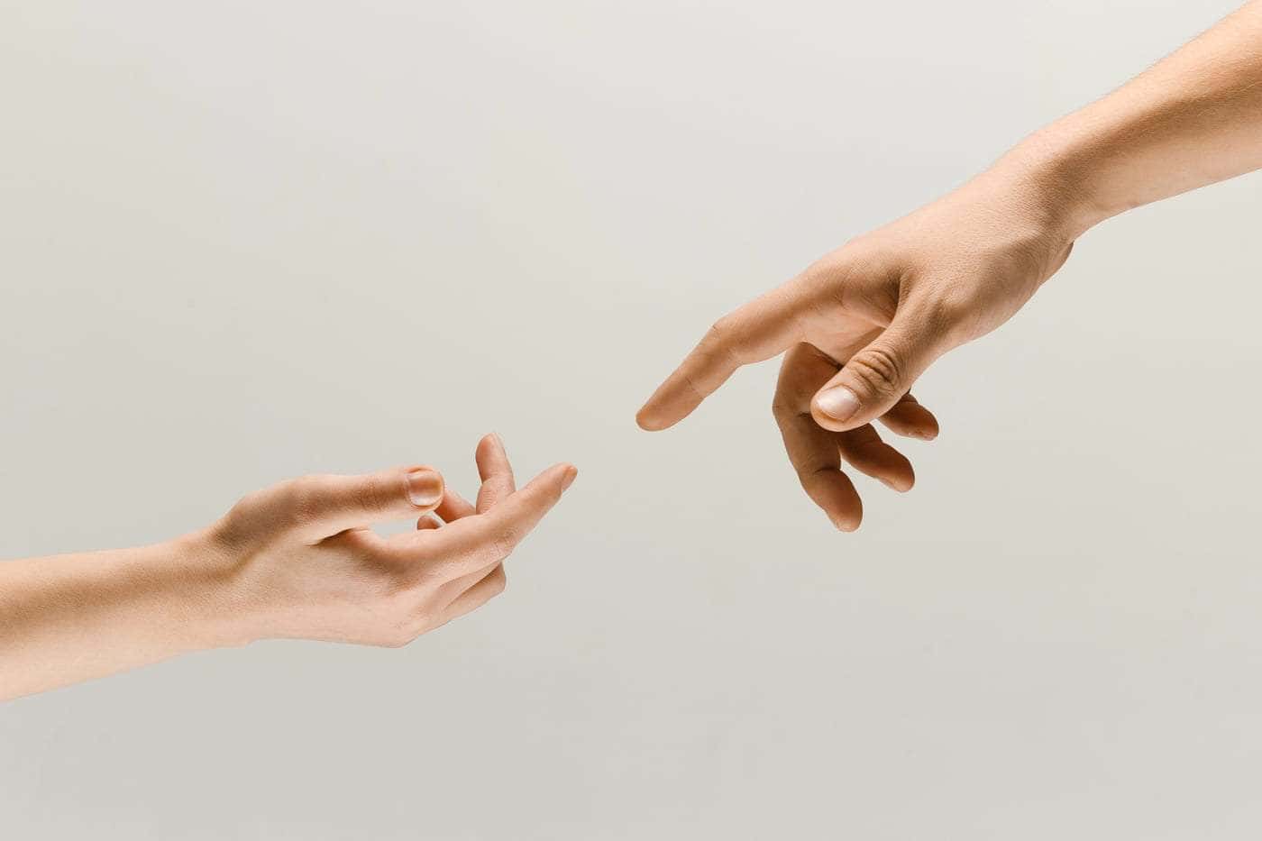 Mano extendida alcanzando otra mano, símbolo de ayuda y conexión.