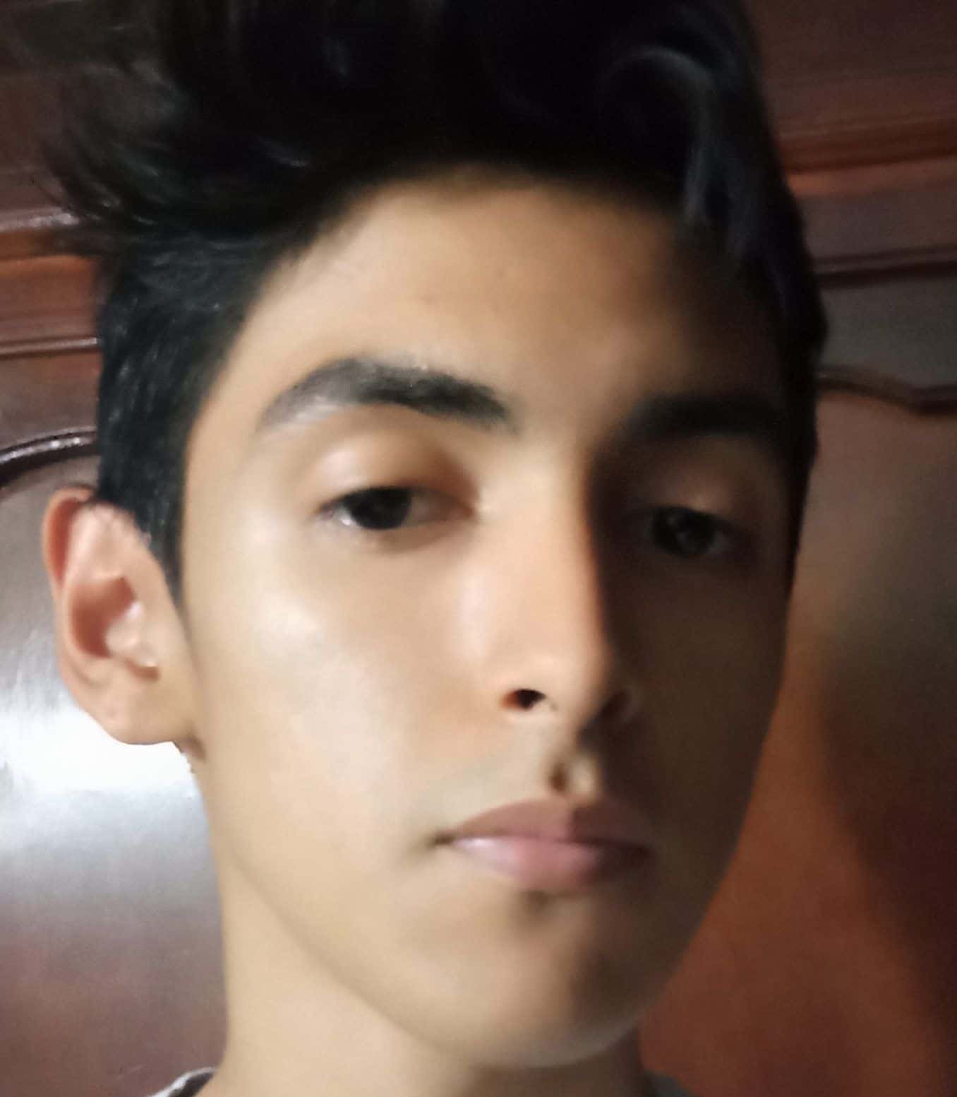 Joven con expresión pensativa en primer plano.