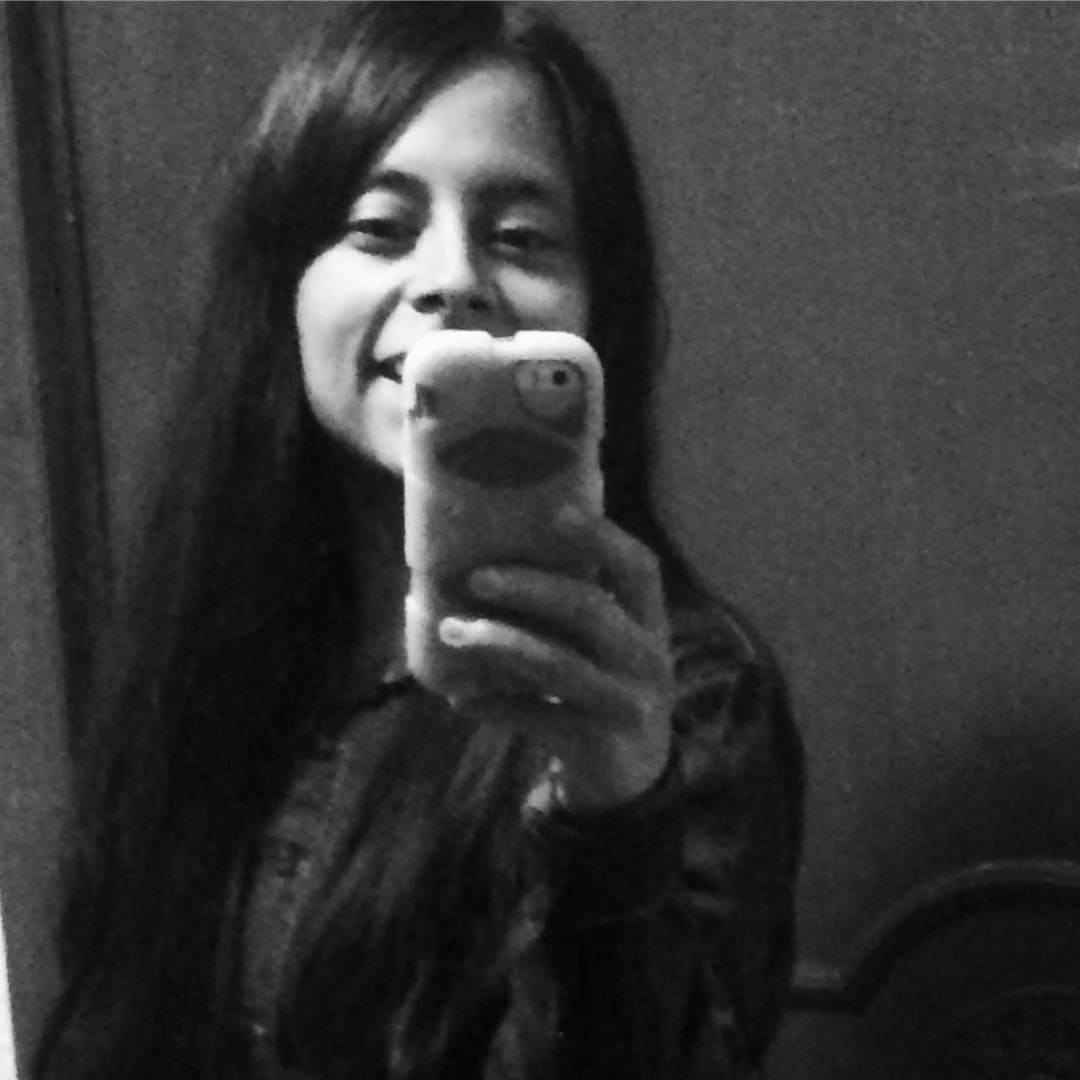 Chica tomando selfie con teléfono en espejo en blanco y negro.