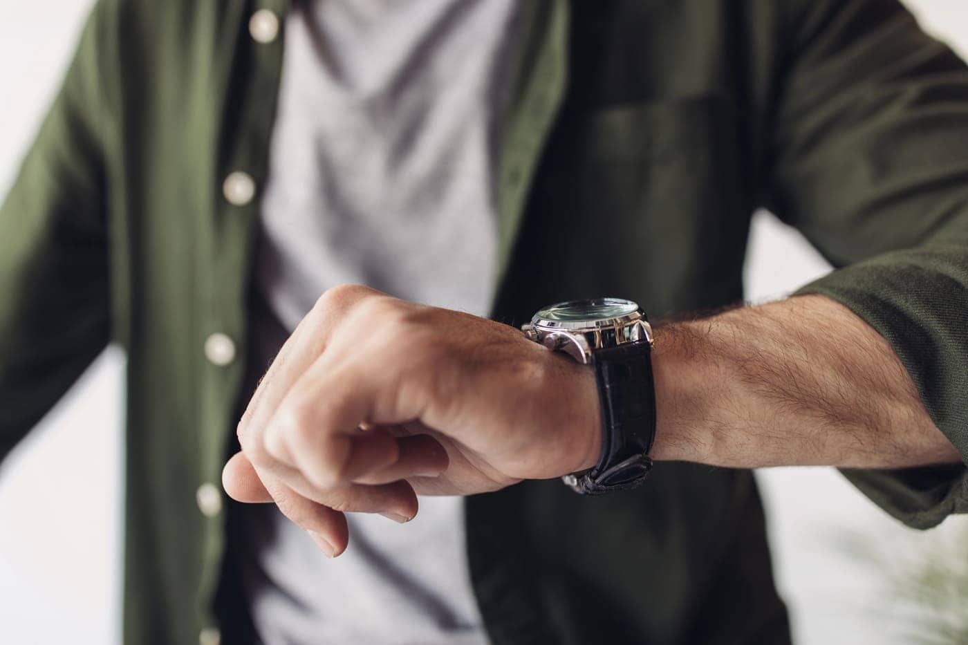 Reloj elegante en la muñeca de un hombre, revisando la hora con estilo y precisión.