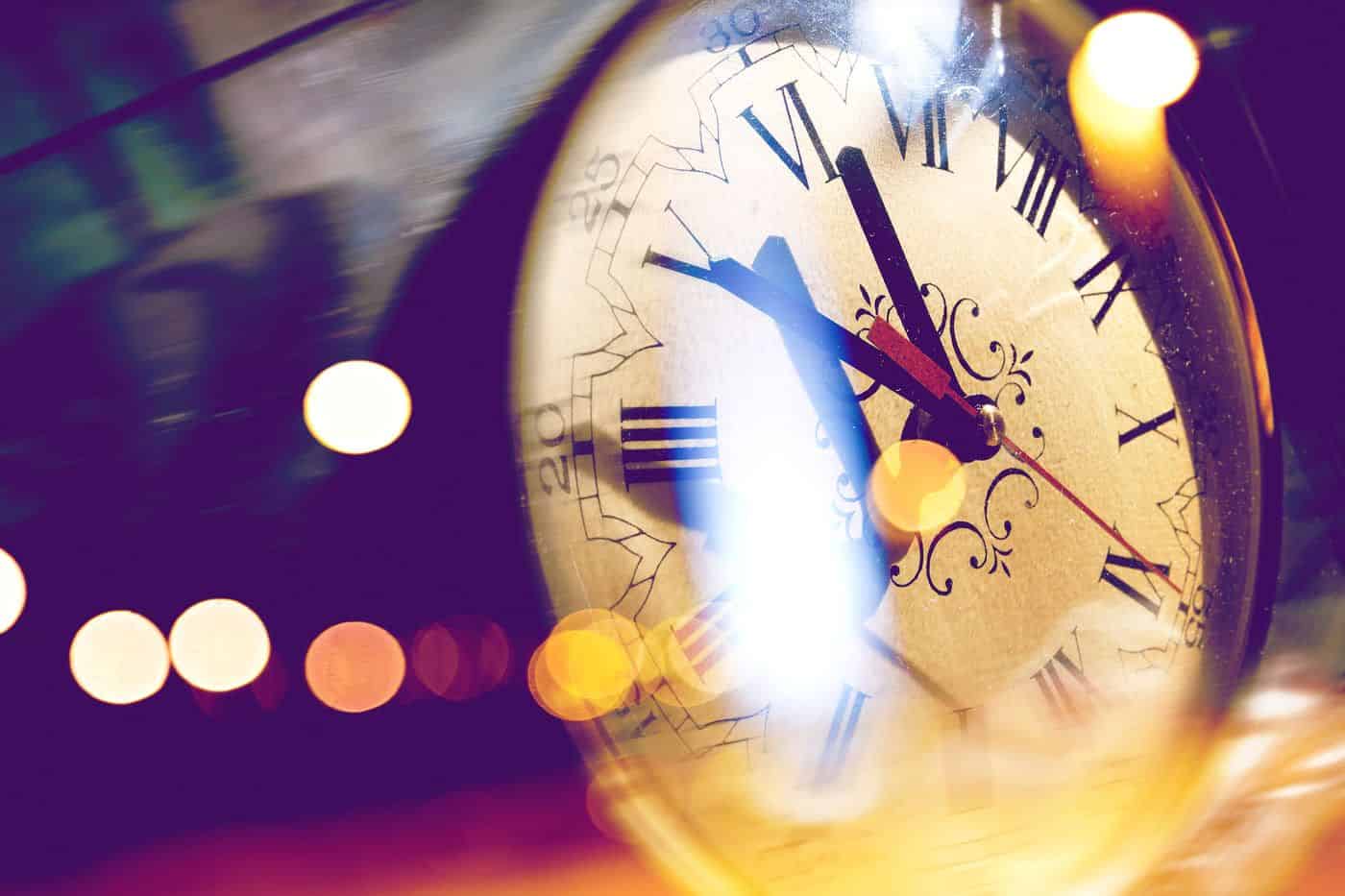 Reloj antiguo con números romanos y reflejos de luces brillantes, simbolizando el tiempo y la reflexión filosófica.
