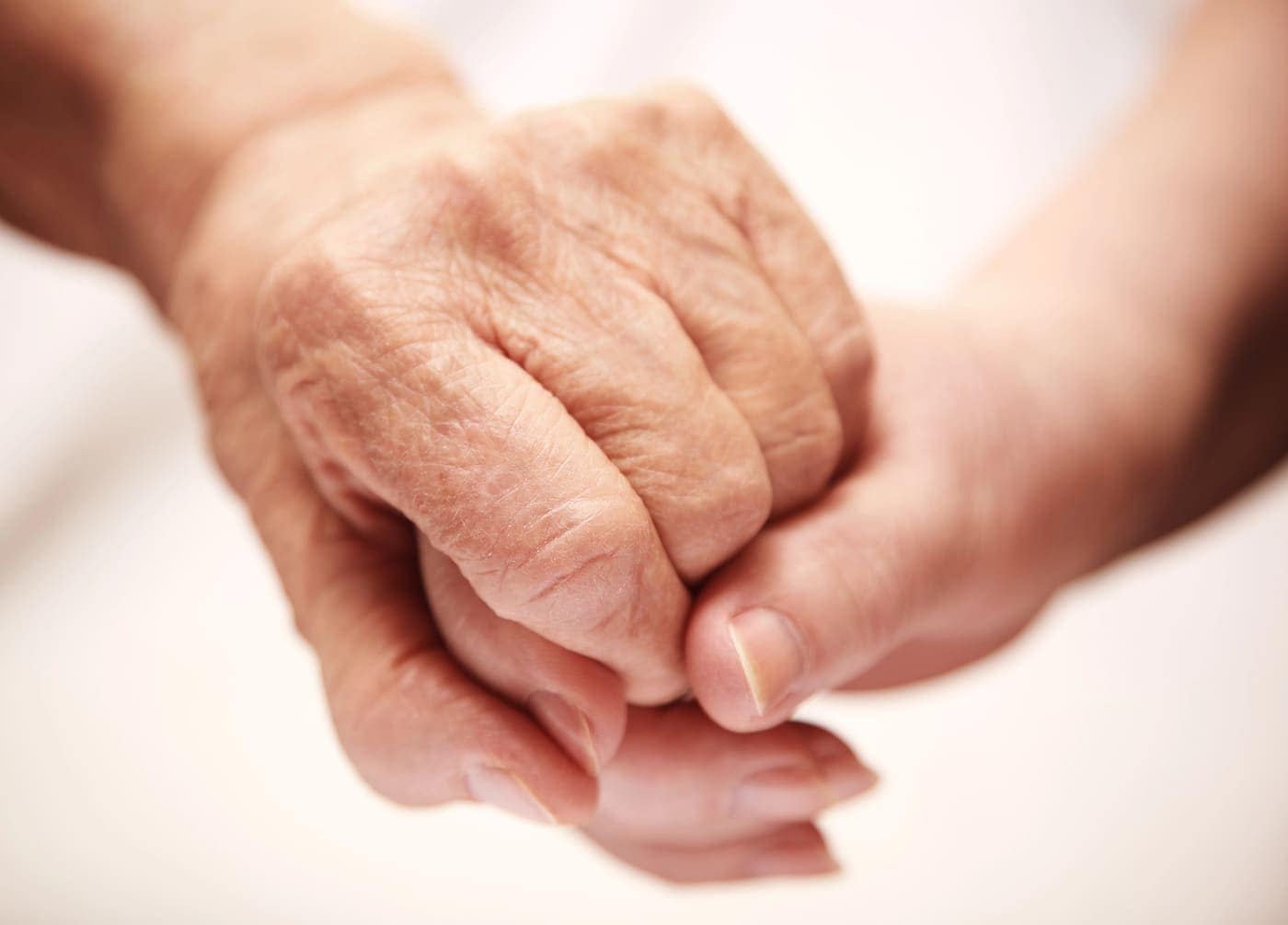 Anciano sosteniendo la mano de otra persona con ternura y experiencia.