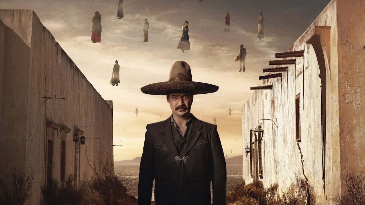 Filósofo con sombrero gigante en escenario surrealista con figuras flotantes en el cielo.