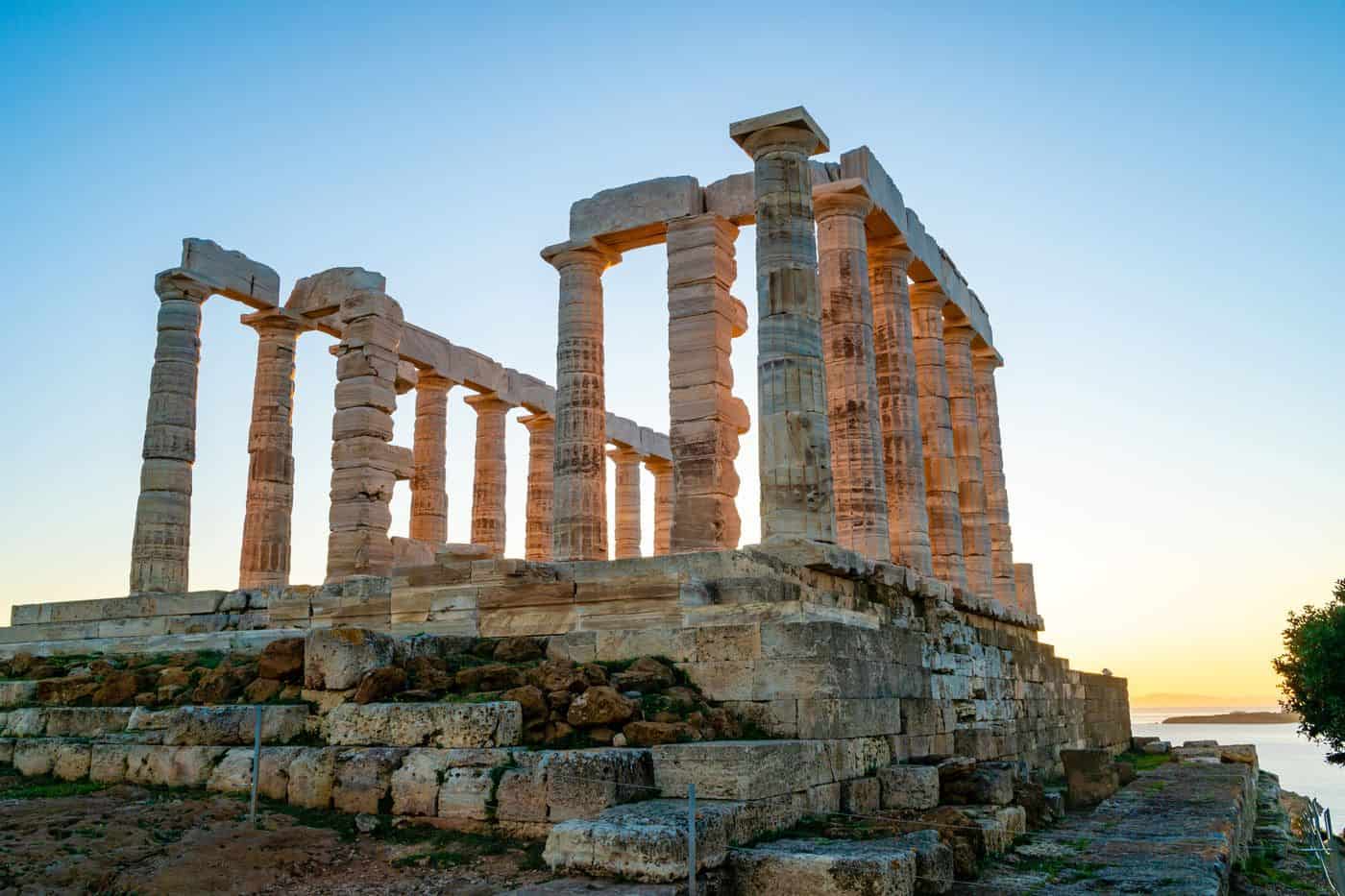Ídolo griego en ruinas al atardecer, símbolo de filosofía y antigüedad clásica.