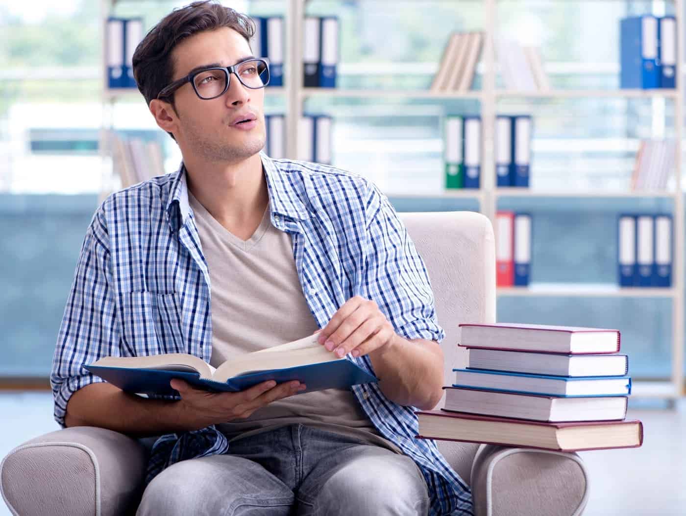 Pensador joven reflexionando en una biblioteca con libros.
