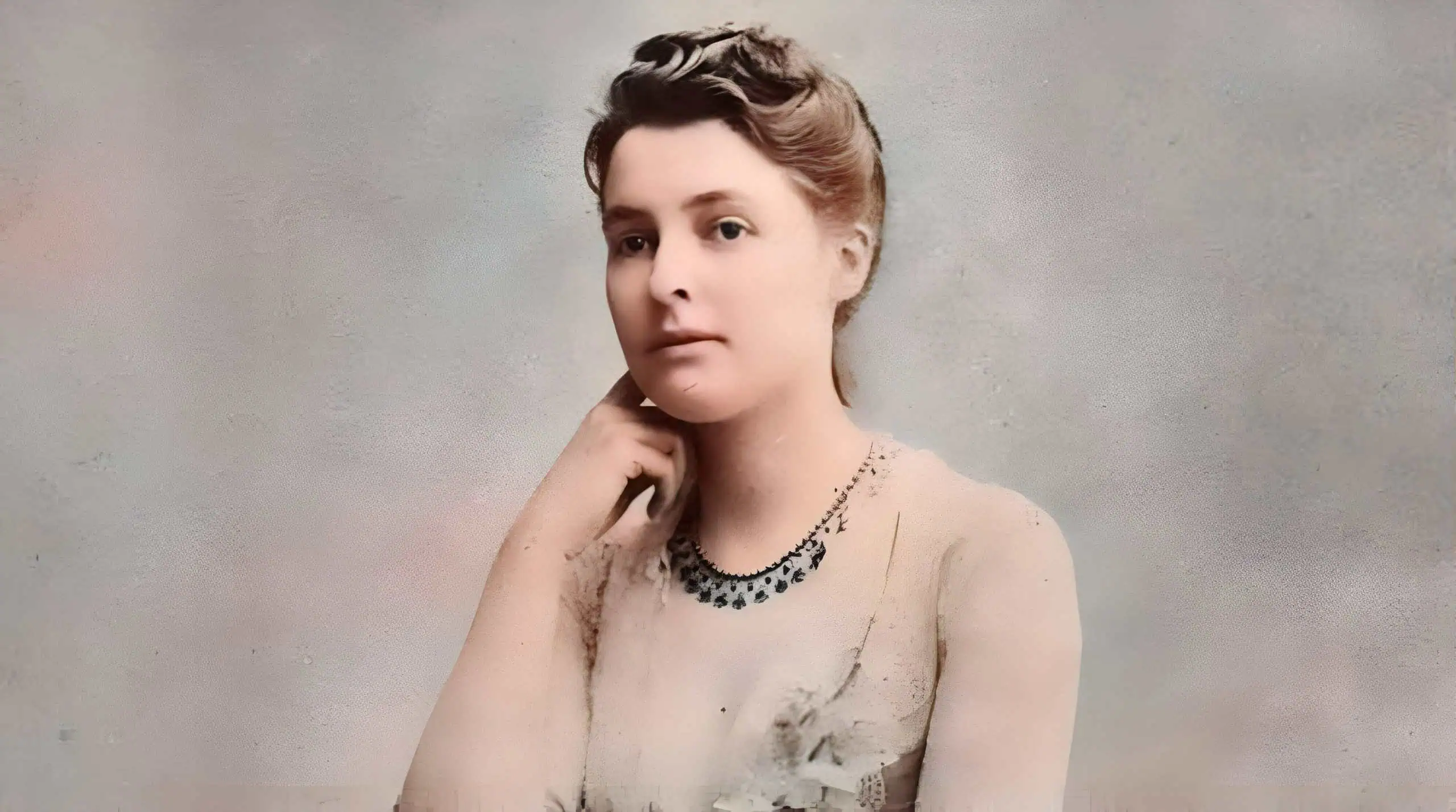 Retrato de mujer con peinado vintage y collar elegante, en un fondo neutro y desenfocado.