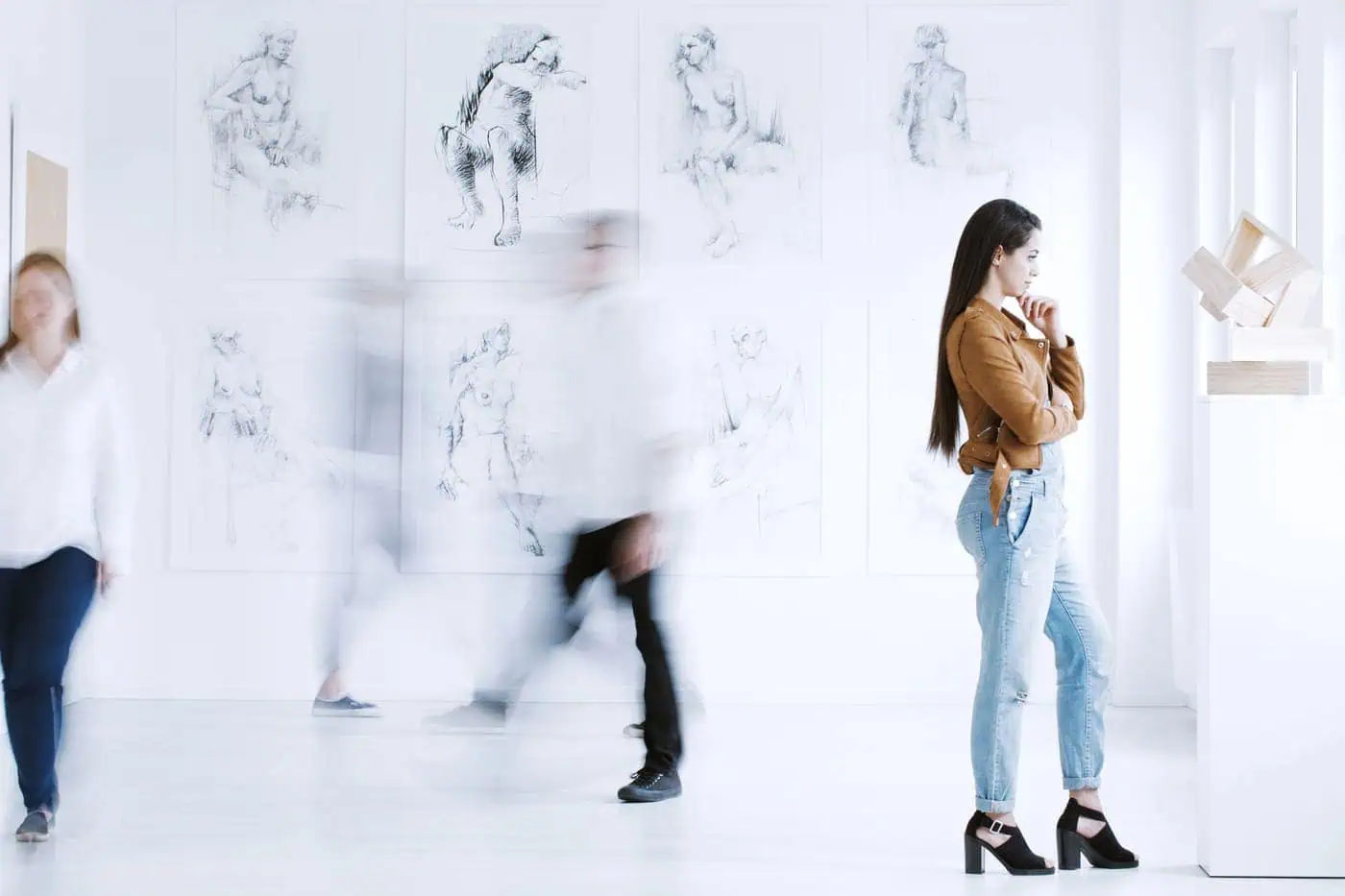 Arte en movimiento en una galería de museos con mujeres observando esculturas y dibujos clásicos.