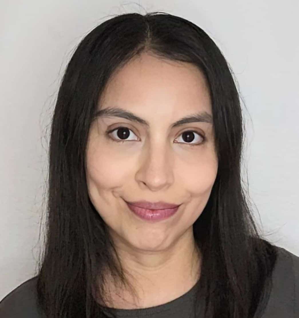 Retrato de mujer joven con cabello negro, sonrisa suave y fondo neutro, para contenido de filosofía y divulgación filosófica.