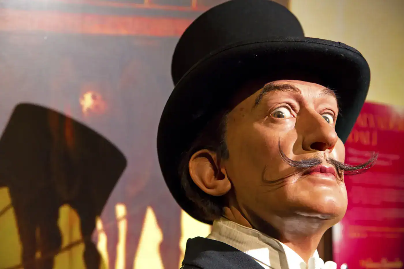 Antínoo, figura histórica con sombrero de copa y bigote característico, en una exposición cultural.