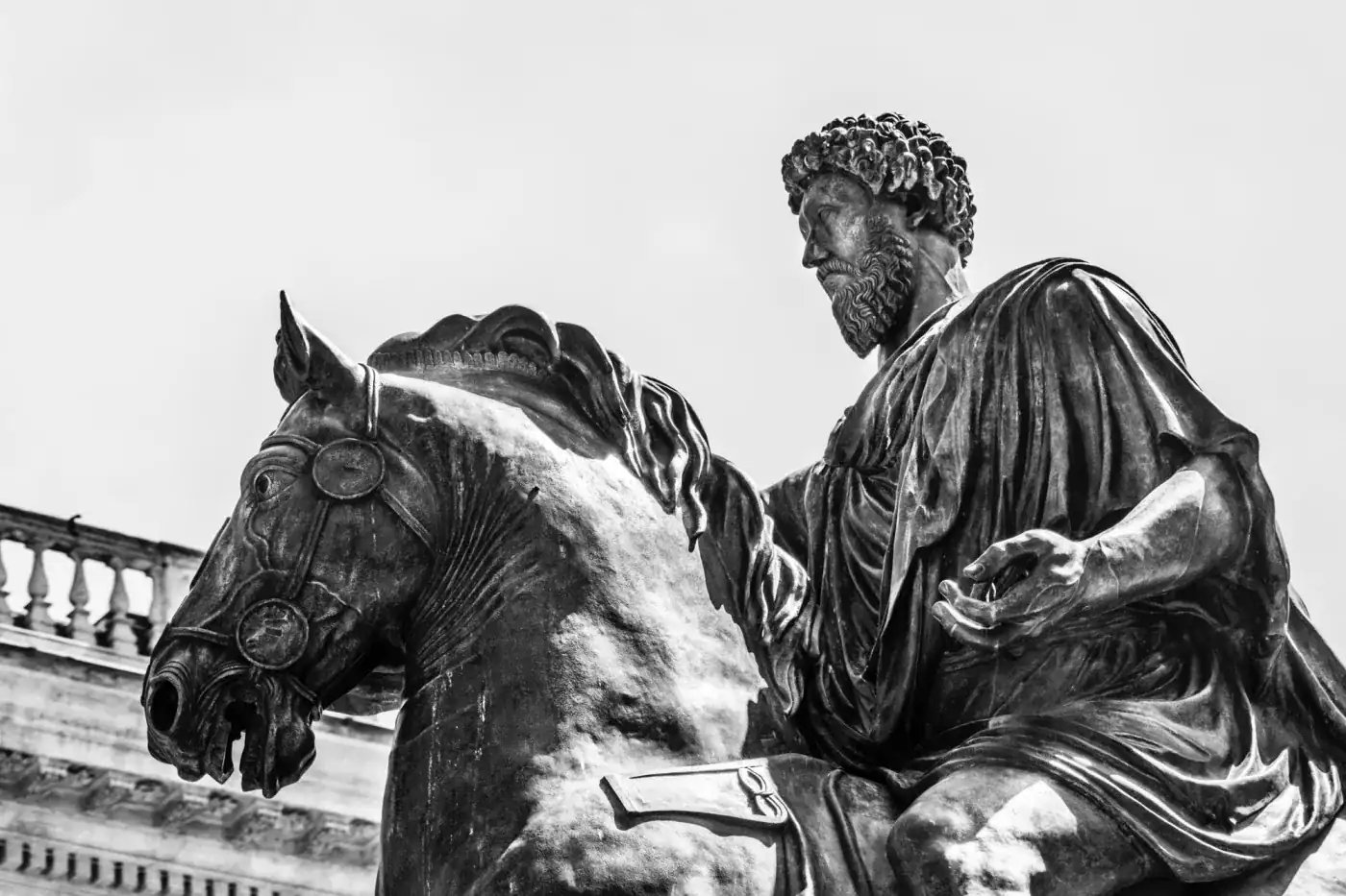 Caballo y filósofo en escultura, representando debate y reflexión filosófica clásica.