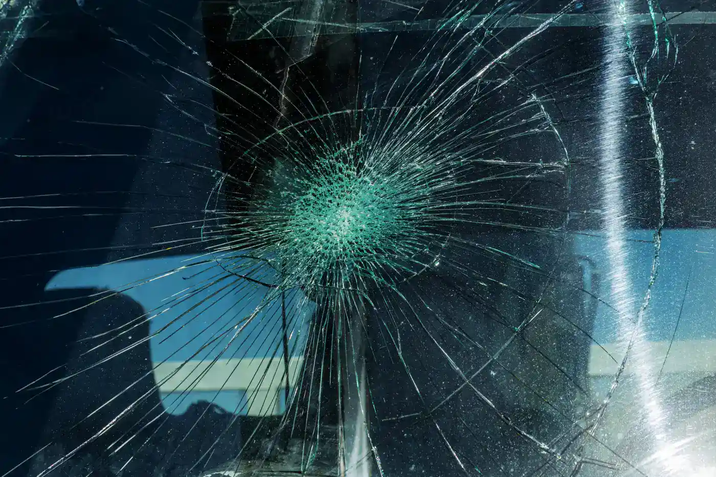 Cristal roto con múltiples grietas en forma de explosión en coche.