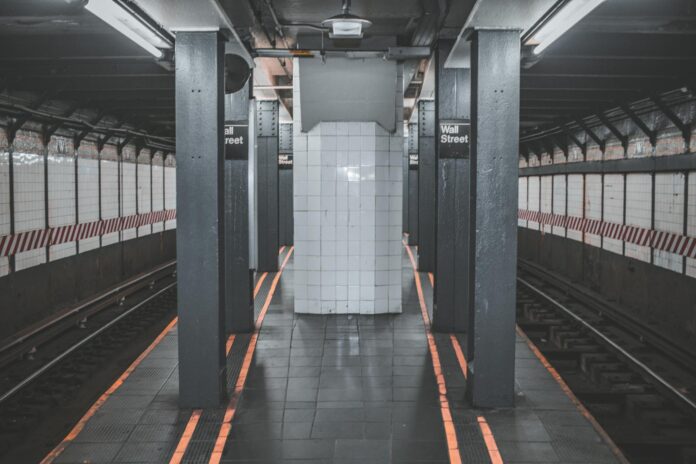 A deserted view of the Wall Street subway station platform in New York City.