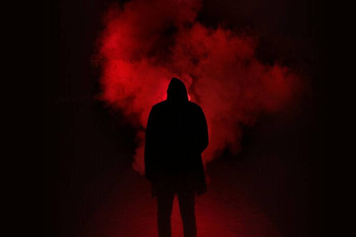 a man standing in a dark red smoke