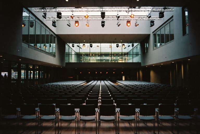 Modern conference hall with lit stage and amber spotlights representing the Accounting Controlling and Finance Summit Düsseldorf 2026