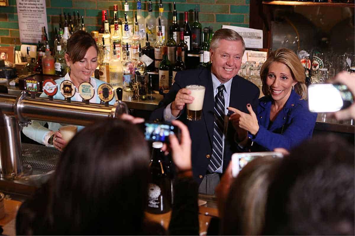 Dana Bash, Senator Lindsey Graham, and his sister Darline Graham Nordone serve guests prior to CNN's Politics On Tap at Walnut Brewery on October 27, 2015 in Boulder, Colorado. 25763_001