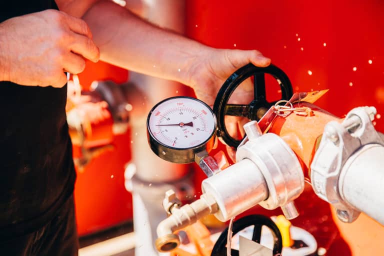 man checking fire hydrant booster